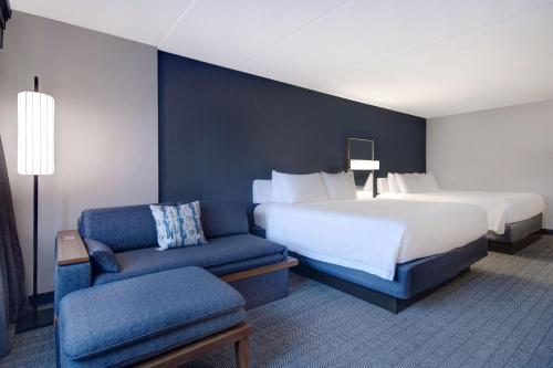 a hotel room with a bed and a chair at Courtyard by Marriott State College in State College