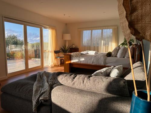 a living room with a couch and a bed and a window at Sailor's Catch in Hokitika