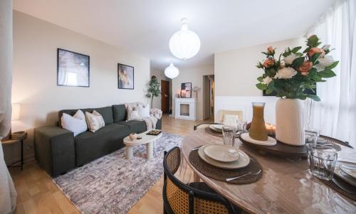 ein Wohnzimmer mit Sofa und Tisch in der Unterkunft Appartement avec Rétroprojecteur, Babyboot avec belle vue et proche gare in Saint-Pierre-des-Corps