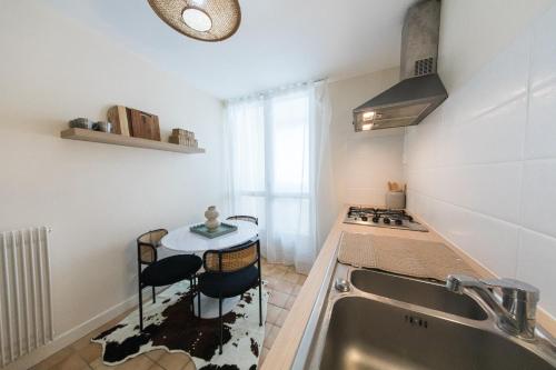 eine kleine Küche mit Spüle und Herd in der Unterkunft Appartement avec Rétroprojecteur, Babyboot avec belle vue et proche gare in Saint-Pierre-des-Corps