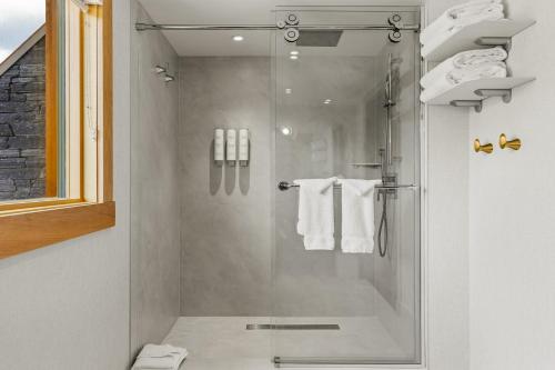 a bathroom with a shower with white towels at Otter Hotel in Banff