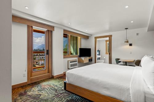 a bedroom with a bed and a large window at Otter Hotel in Banff