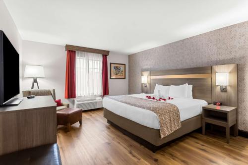 a hotel room with a large bed and a desk at Best Western Moriarty Heritage Inn in Moriarty
