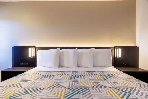 a bed with white pillows in a hotel room at Motel 6 Portland OR Southeast in Portland
