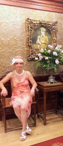 a woman sitting on a chair in a room with a picture at Historic Wilson-Guy House in Niagara on the Lake