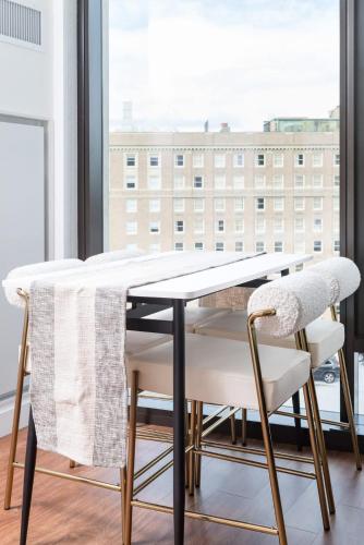 a dining room table with chairs and a window at Back-Bay 2BR Condo w Roof top Gym Parking in Boston