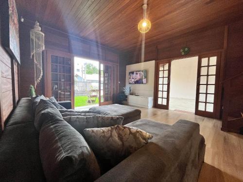 邦比尼亚斯B167 - Casa de Alto Padrão com Piscina Privativa e Espaço Gourmet a 450m do Mar na Praia de Mariscal - Bombinhas-SC的配有沙发和桌子的大客厅