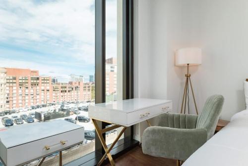 a bedroom with a bed and a desk and a window at Back-Bay 2BR Condo w Roof top Gym Parking in Boston