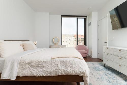 a white bedroom with a large bed and a window at Back-Bay 2BR Condo w Roof top Gym Parking in Boston