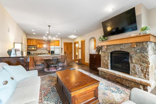 a living room with a stone fireplace with a tv at Lone Eagle 3017 in Keystone