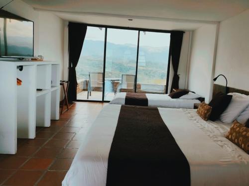 a hotel room with two beds and a television at Sierra Morena Hotel in Filandia