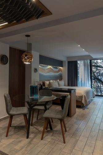 a bedroom with a desk and a bed and a table and chairs at Suites MINE in Mexico City