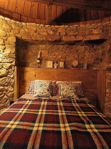 a bedroom with a bed in a stone wall at Moinho da Alfazema in Penacova