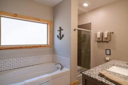 a bathroom with a tub and a sink and a window at Alpine Lodge - Epic Mountain Views, Hot Tub, 2 Miles to Town in Leavenworth