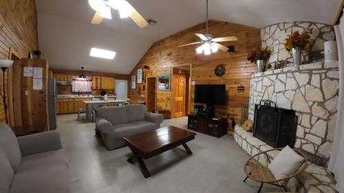a living room with a couch and a stone fireplace at 2 Homes Laurel Canyon and Cherokee Oaks in Concan
