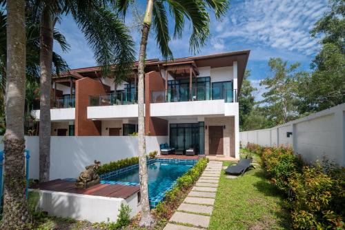 a house with a swimming pool and palm trees at Kamala Beach 3-bedroom villa near Fantasea with high-speed Wi-Fi and private pool in Kamala Beach