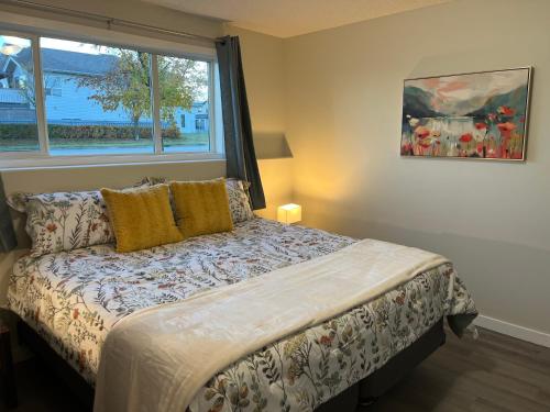 Un dormitorio con una cama con una ventana grande. en Park View Paradise - Big, Bright, Modern, Fully Stocked, en Grande Prairie