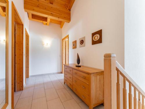 a hallway with a wooden staircase and a wooden dresser at Maxima - Ski in - Ski Out in Flecken