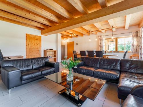 a living room with leather furniture and a wooden ceiling at Maxima II - Ski in - Ski Out in Flecken