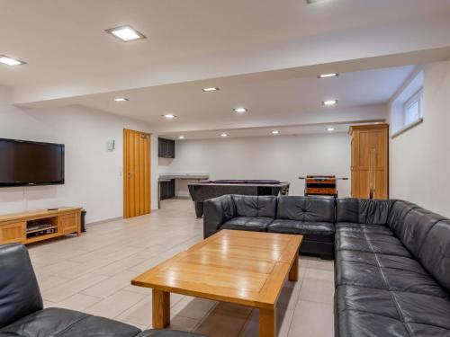 a living room with a leather couch and a table at Maxima II - Ski in - Ski Out in Flecken