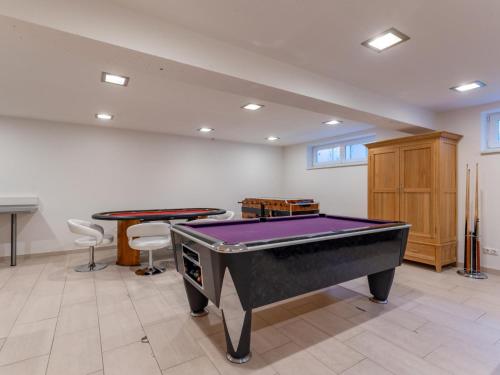 a room with a pool table and two tables at Maxima II - Ski in - Ski Out in Flecken
