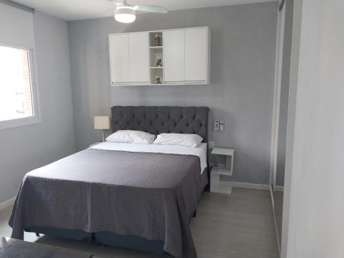 ein Schlafzimmer mit einem großen Bett mit einem grauen Kopfteil in der Unterkunft Dot Home Guanabara - Lindo Apartamento Mobiliado em Campinas in Campinas