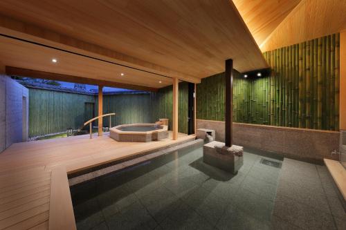 a bathroom with a tub in the middle of a room at 天童荘 TENDOSO in Tendo