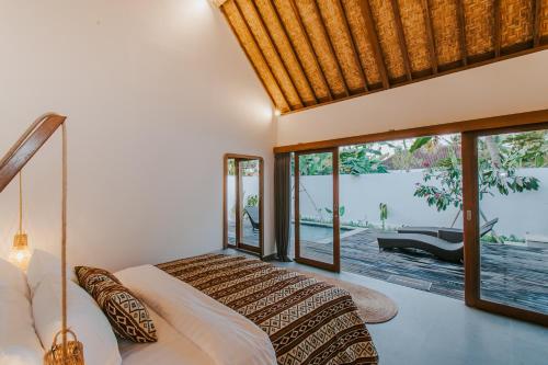 a bedroom with a bed and a view of a pool at Villa Diamond Lembongan in Nusa Lembongan