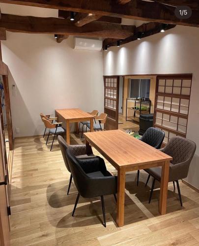 a room with wooden tables and chairs in it at Guesthouse TOMARITOMARO in Shikineshima