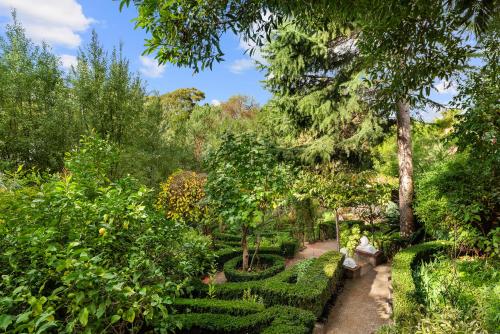 a garden with bushes and trees and a pathway at The Castle - Villa by the Sea in Cowes