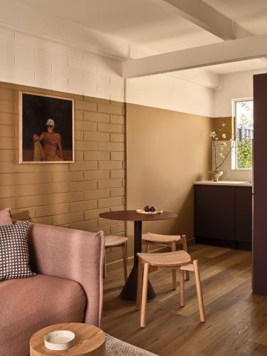 a living room with a couch and a table at Casita Motel in Batehaven