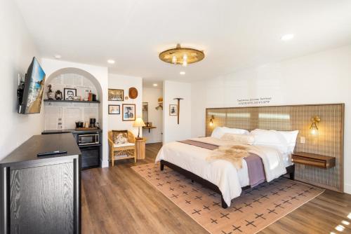 a bedroom with a large bed and a kitchen at Inn History Tombstone in Tombstone