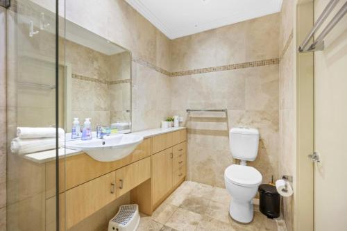 a bathroom with a toilet and a sink and a shower at Family 3BR 2-level Home at Central Chatswood in Sydney
