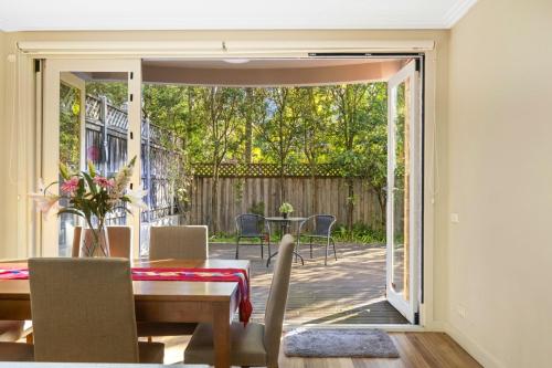 an open door to a patio with a table and chairs at Family 3BR 2-level Home at Central Chatswood in Sydney