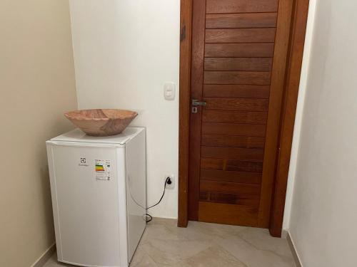 Casa Dendê - Arraial D'Ajuda في ارايال دايودا: وعاء فوق الثلاجة بجوار الباب