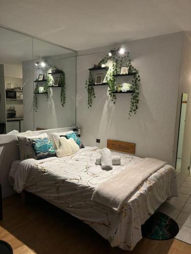 a bedroom with a bed with plants on the wall at La belle étape et Parking in Carquefou