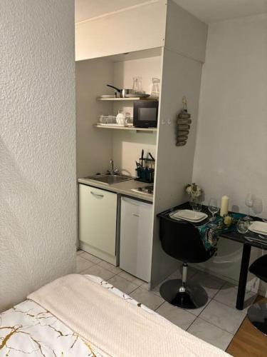 - une petite cuisine avec un bureau et un lit dans une chambre dans l'établissement La belle étape et Parking, à Carquefou