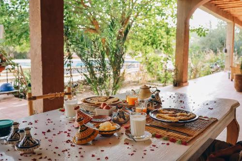 スコーラにあるRIAD AMAN SKOURAの食べ物と飲み物の盛り合わせが付いたテーブル