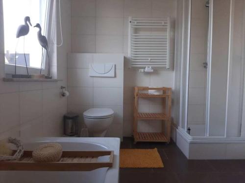 a bathroom with a tub and a toilet and a window at "thousand lakes" Comfortable holiday residence in Marienfelde