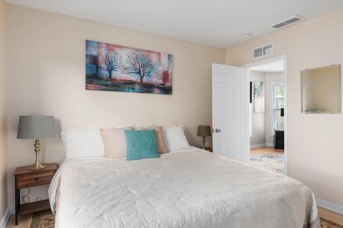 a bedroom with a white bed and a painting on the wall at 2BR Apartment with Private Office Near Downtown - Dahlia in Minneapolis