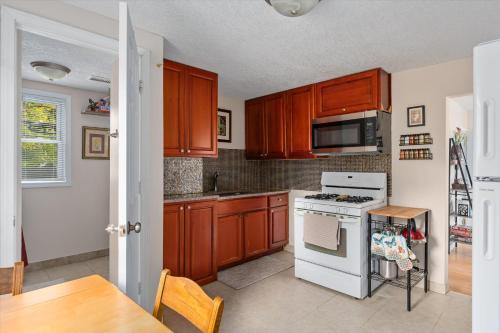 a kitchen with wooden cabinets and a white stove top oven at 2BR Apartment with Private Office Near Downtown - Dahlia in Minneapolis
