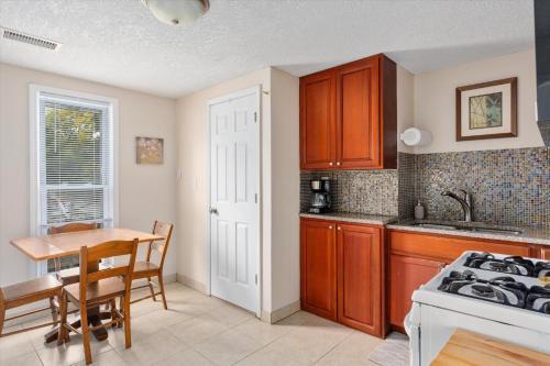 a kitchen with wooden cabinets and a table and a stove at 2BR Apartment with Private Office Near Downtown - Dahlia in Minneapolis