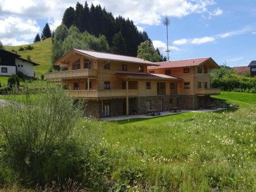 a large wooden house in a field of grass at Resl Haus 1 Comfortable holiday residence in Jungholz