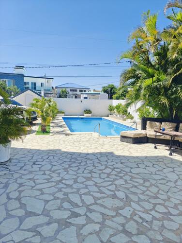 a swimming pool in a yard with palm trees at Sosua Sweet Vacations in Sosúa
