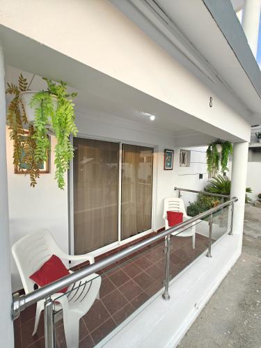 a balcony with two chairs and a window at Sosua Sweet Vacations in Sosúa