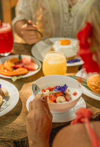 a person sitting at a table with a bowl of food at Arrecifes Refugio Natural in Santa Marta