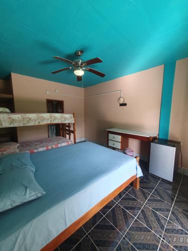 a bedroom with a bed and a ceiling fan at River Park Inn in San Ignacio
