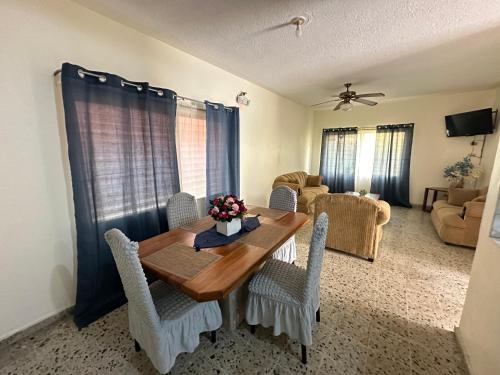 a living room with a wooden table and chairs at Villas del Mar in La Ceiba