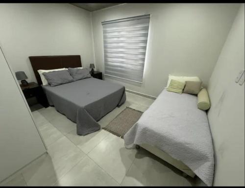 a bedroom with two beds and a window in it at Dpto Edificio Marlin Luque in Luque