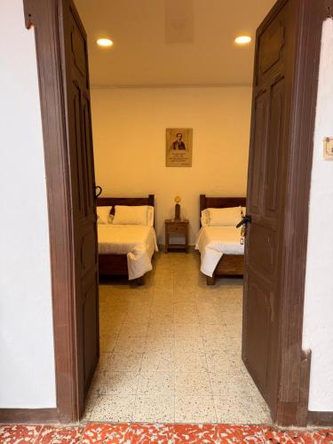 a room with two beds and a door open at Vivienda turística Casa Rionegro Colonial in Rionegro